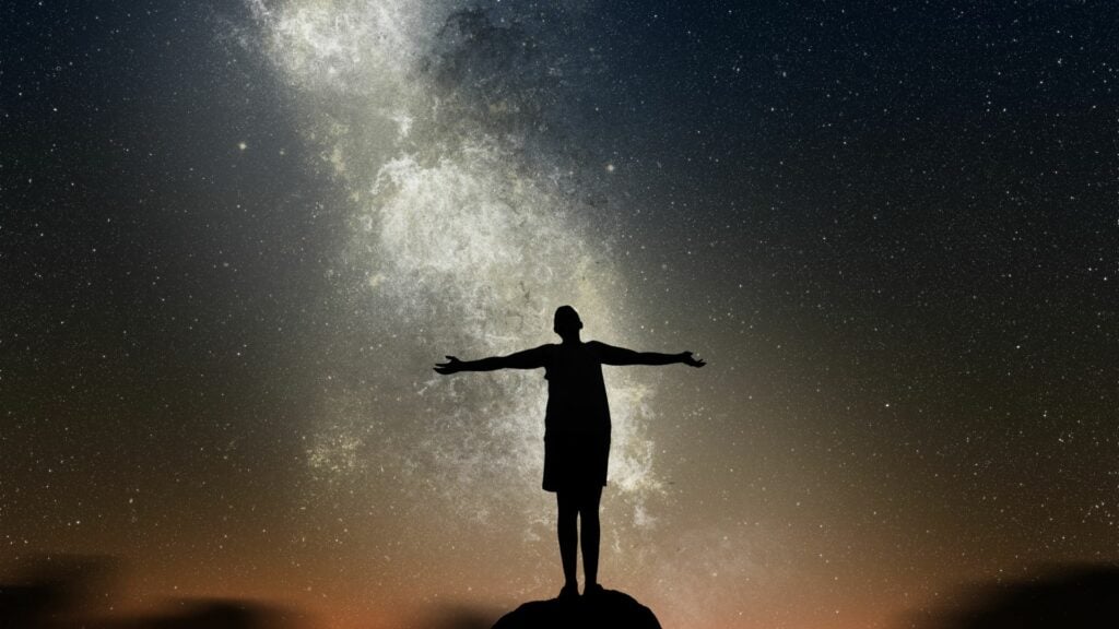 Imagem de um homem olhando para o universo.
