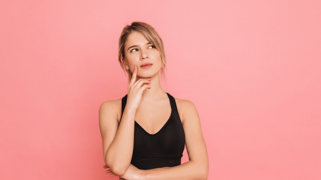 Uma mulher loira está olhando para o lado e tem uma expressão de dúvida ou questionamento no rosto.