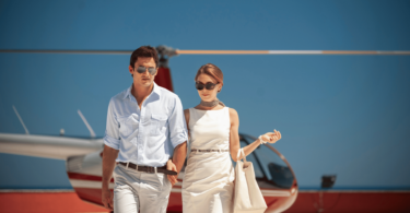 Um casal rico composto por uma mulher e um homem estão saindo de um helicóptero.