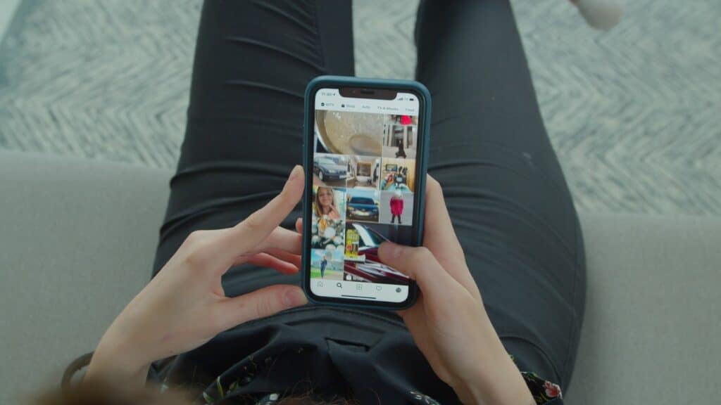 Imagem de uma jovem garota colocando suas fotos no feed do instagram.
