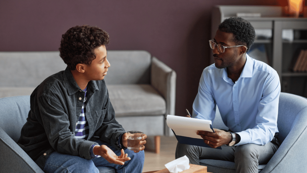 Um adolescente está em uma sessão de terapia com seu psicólogo. Eles conversam.