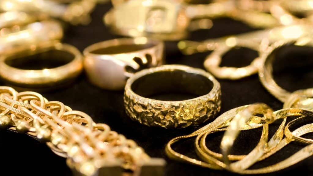 Imagem de muitas joias de ouro como: pulseiras, colares, correntes e aneis.