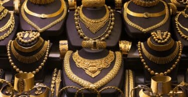 Imagem de uma vitrine de loja onde estão expostas várias joias de ouro.