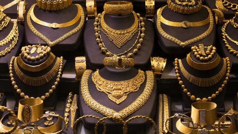 Imagem de uma vitrine de loja onde estão expostas várias joias de ouro.