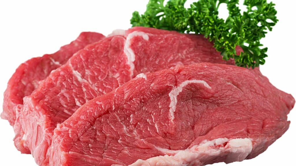 Imagem de três pedaços de carne de boi feitos para bife.