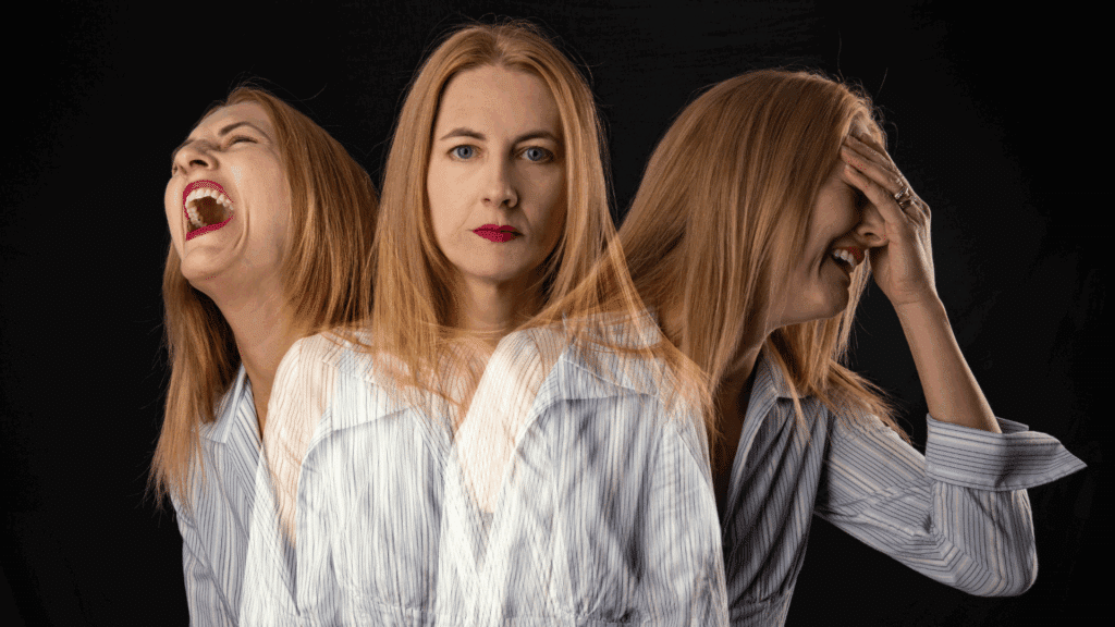 Um mulher está representada em três versões de si com diferentes expressões faciais: uma caótica, outra séria e outra abalada, indicando flutuação emocional.