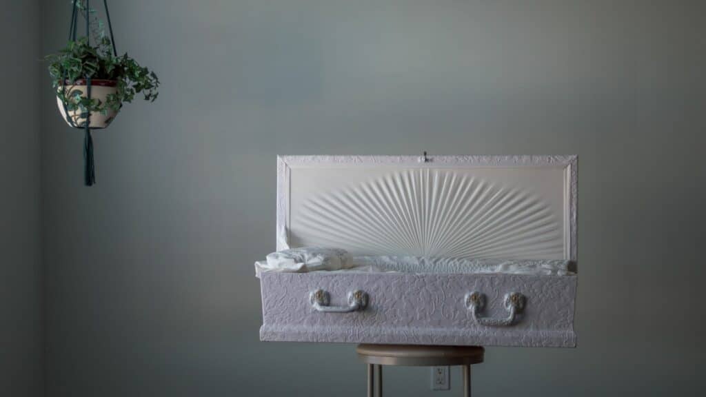 Imagem de um caixão branco e pequeno de um bebê morto.