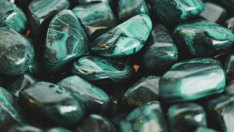 Imagem de muitas pedras de jaspe na cor verde escuro.