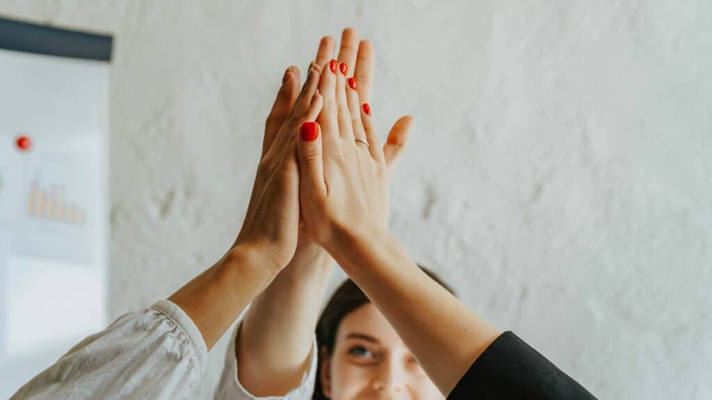 Imagem com um grupo de pessoas em um ambiente corporativo, trazendo o conceito de energia positiva e de coletividade.