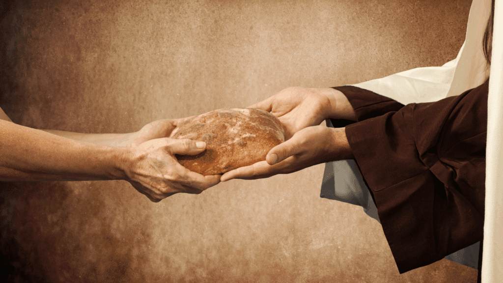 Na imagem, Jesus está oferecendo um pão a uma pessoa.