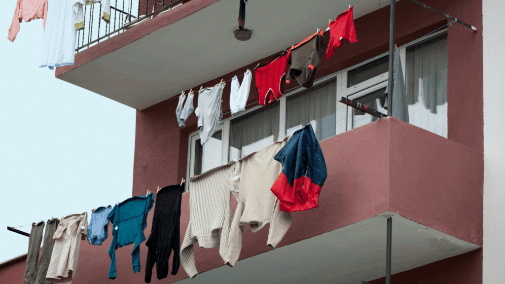 Há um prédio e algumas roupas no varal penduradas do lado de fora dos apartamentos.