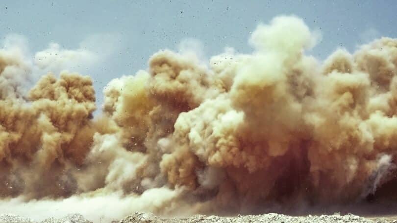 Imagem de uma nuvem de poeira tocando o chão do deserto.