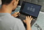 Um homem está mexendo no seu notebook. Ele está usando o ChatGPT.