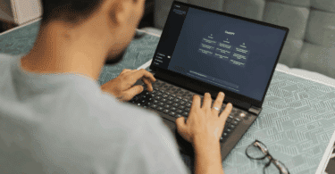 Um homem está mexendo no seu notebook. Ele está usando o ChatGPT.