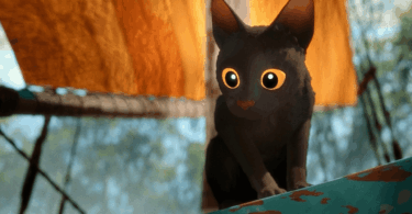 O gato preto e protagonista do filme de animação "Flow" está em cima de um barco. Ele olha para baixo.