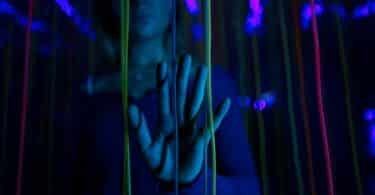 Imagem da mão de pessoa com luzes azuis e roxas, simbolizando o Transtorno da Sobrecarga Sensorial - TSS