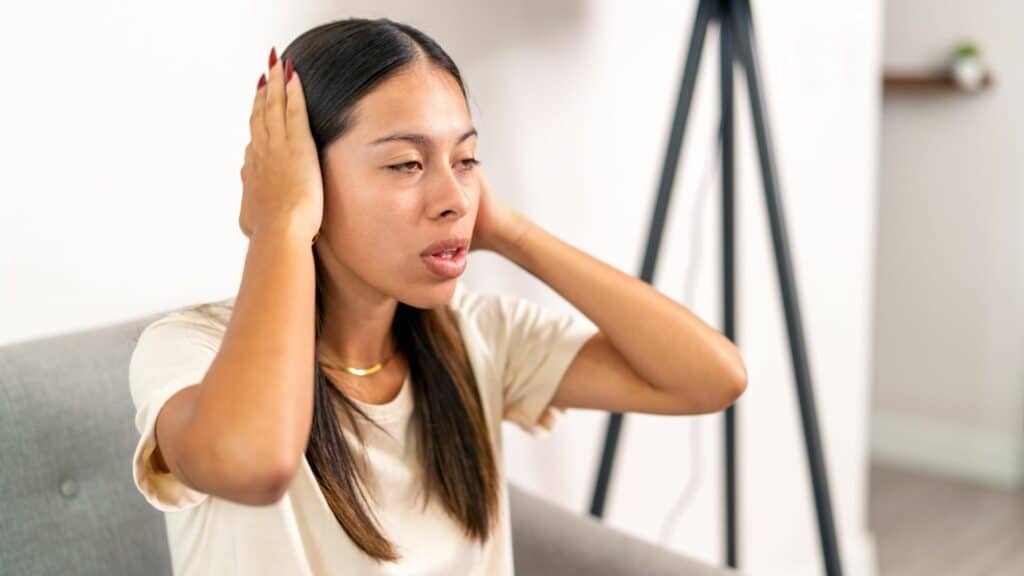 Imagem de uma mulher com os sintomas do  Transtorno da Sobrecarga Sensorial.