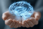 Ilustração de um cérebro holográfico azul e luminoso flutuando acima de mãos abertas, simbolizando mente, inteligência e tecnologia.