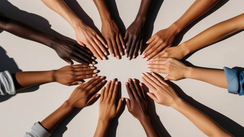 Imagem de vários tipos de mãos unindo-se em unidade, trazendo o conceito de pertencimento.