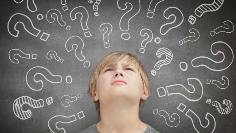 Imagem de um adolescente com a cabeça erguida e ao fundo vários sinais de interrogação sobre a sua cabeça, simbolizando os pensamentos.