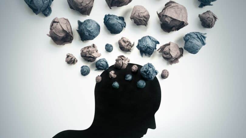Imagem da silhueta da cabeça de um ser humano e sobre ela, várias bolas feitas de papel, simbolizando a exaustão mental.