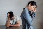 Um casal composto por um homem e uma mulher demonstram tensão e tristeza em um momento de conflito ou distanciamento emocional.