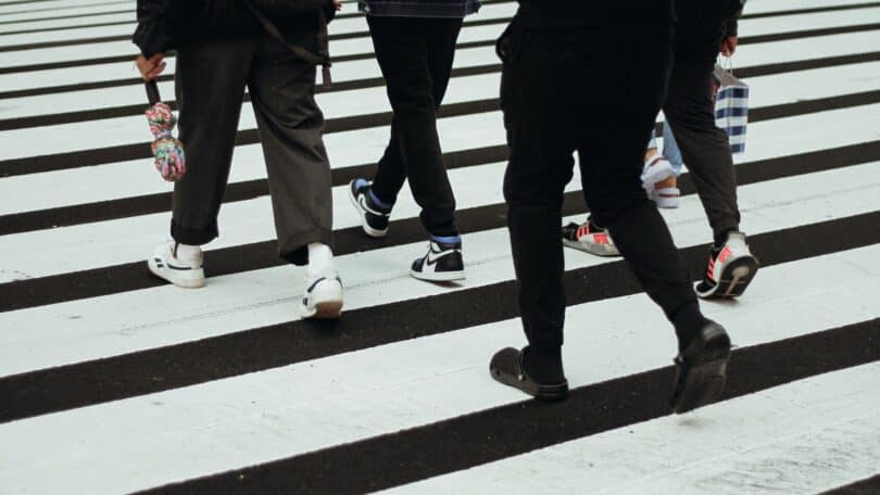 Imagem de várias pessoas caminhando e atravessando em uma faixa de pedestres, olhando apenas para o horizonte, simbolizando a autonomia que cada pessoa tem.