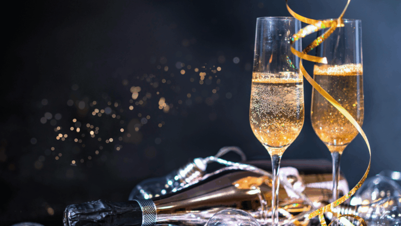 Taças de espumante e decoração festiva criam uma atmosfera elegante de celebração e confraternização.