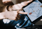 Mulher aponta para um gráfico numerológico em tablet, explorando padrões e interpretações ligadas ao autoconhecimento e ao desenvolvimento pessoal.