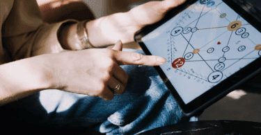 Mulher aponta para um gráfico numerológico em tablet, explorando padrões e interpretações ligadas ao autoconhecimento e ao desenvolvimento pessoal.