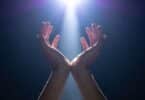 Imagem das mãos de um homem erguidas para um feixe de luz, simbolizando a centelha divina.