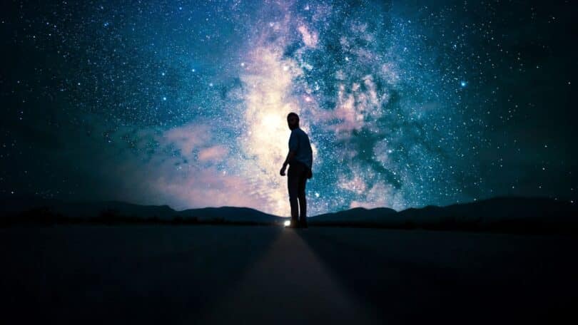 Imagem da silhueta humana olhando para o universo/céu estrelado, sugerindo a ideia de realidade expandida e percepção limitada.