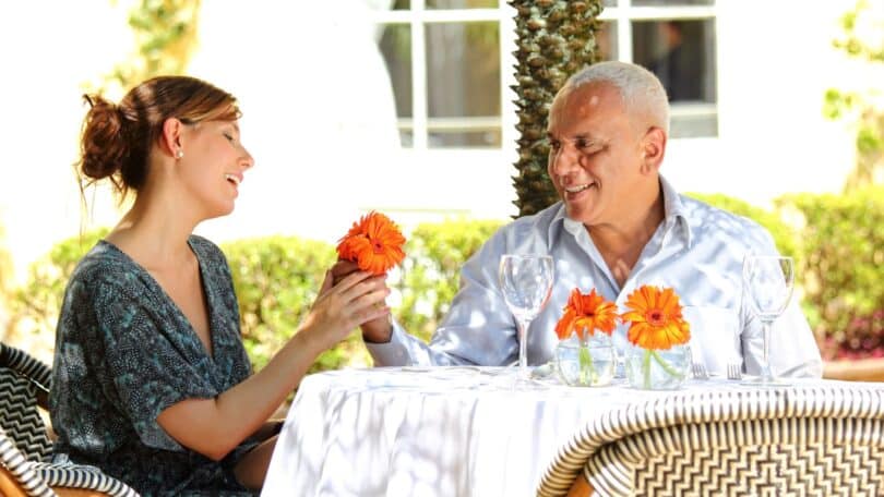 Imagem de duas pessoas felizes, sentadas em uma conversa profunda, olhando uma para a outra com atenção e acolhimento, sem celulares ou distrações ao redor.