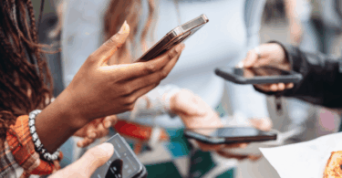 Pessoas seguram smartphones nas mãos, representando uso compartilhado de tecnologia e comunicação digital.