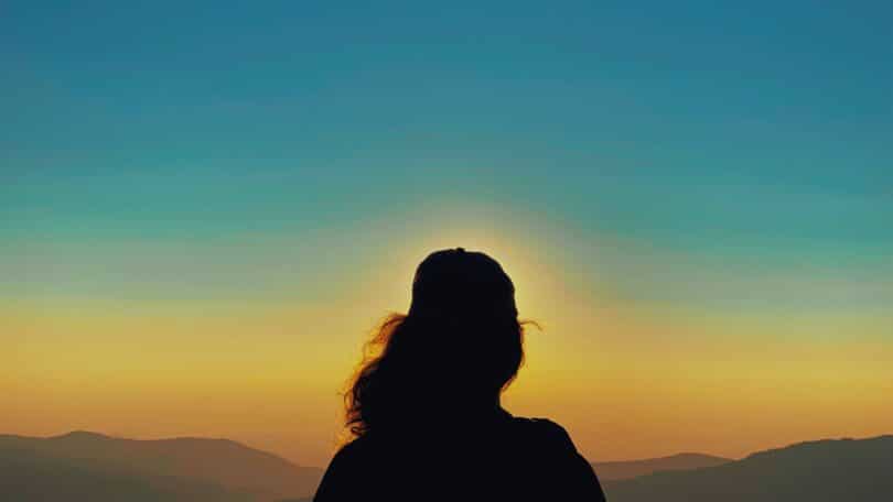 Imagem de uma pessoa contemplando um céu amplo e luminoso, transmitindo sensação de profundidade, presença e conexão com a existência.