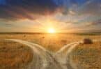 Imagem de uma bifurcação em uma estrada no meio do sertão e ao fundo, um lindo pôr do Sol, simbolizando escolha, mudança, consciência e possibilidade.