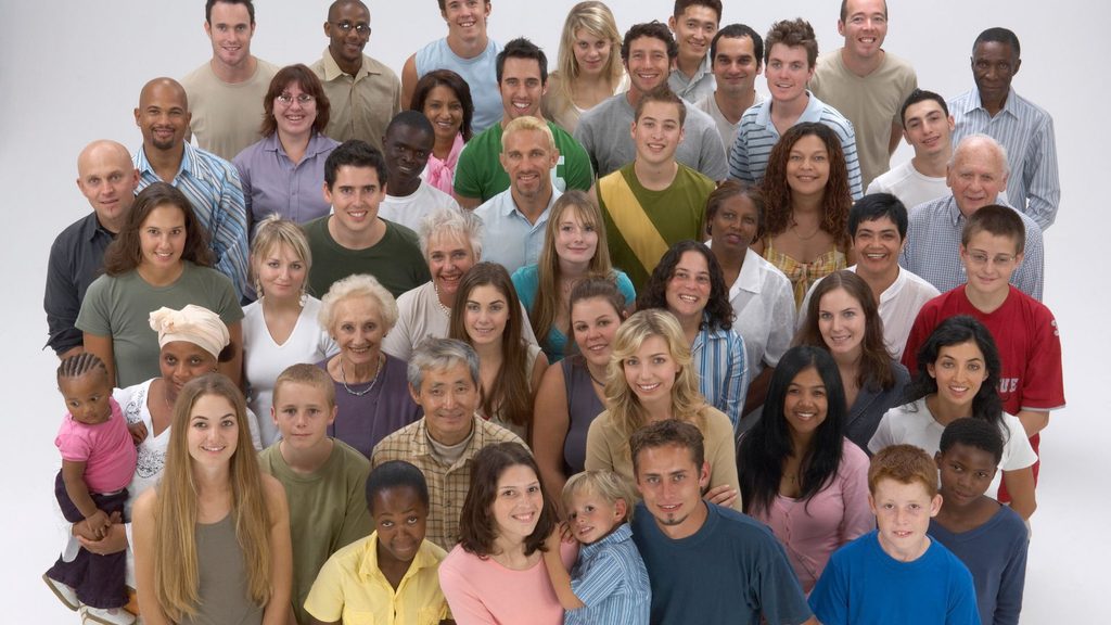 Imagem de várias pessoas com diferentes perfis reunidas em um ambiente natural. A foto traz a importância de escutar opiniões divergentes, reconhecer a diversidade e preservar o respeito nas discussões coletivas.
