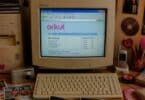 Imagem de um computador antigo com a tela da página inicial do orkut, teclado, fotografias impressas e objetos que remetam ao início dos anos 2000.